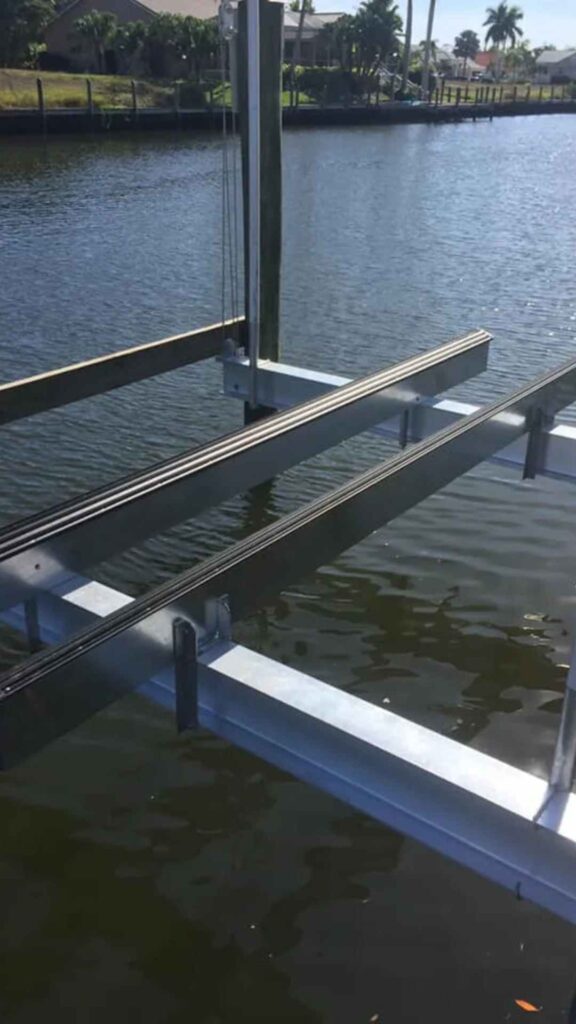 Custom aluminum boat lift with black rubber-coated bunks suspended over water
