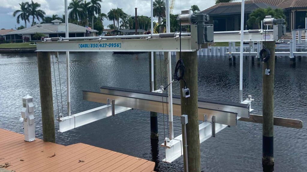 Custom aluminum boat lift with electric winch motors installed on dock pilings