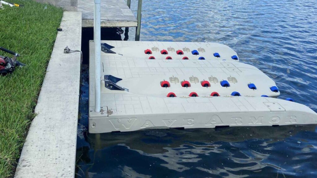 Two Wave Armor PWC ports with colored rollers installed on a residential canal