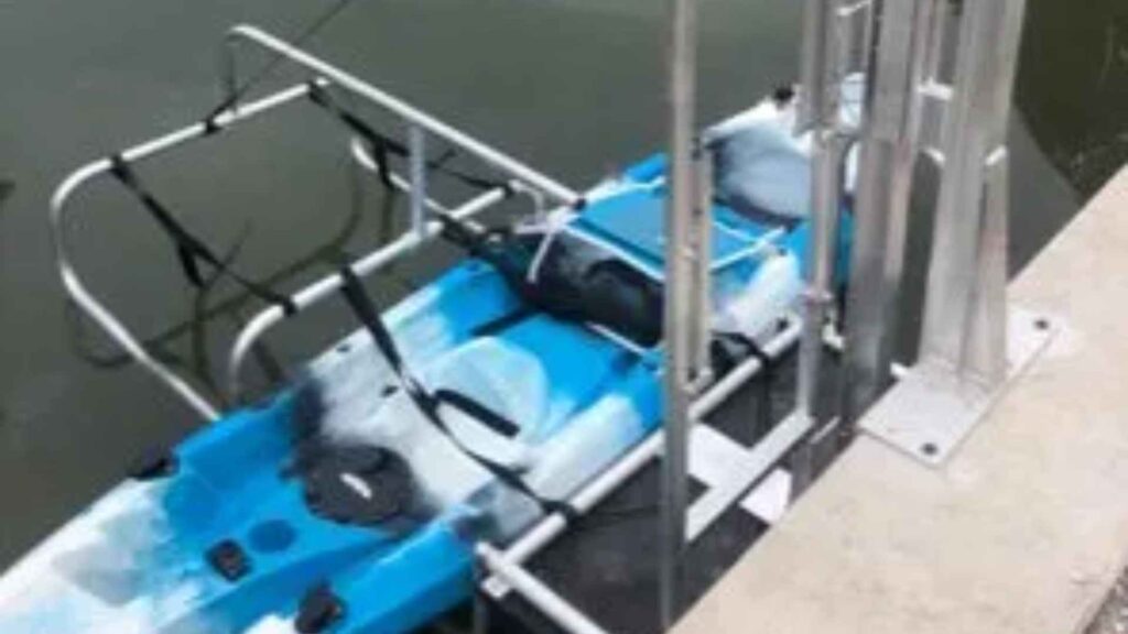 SeaHorse kayak lift holding a blue tandem kayak along a seawall