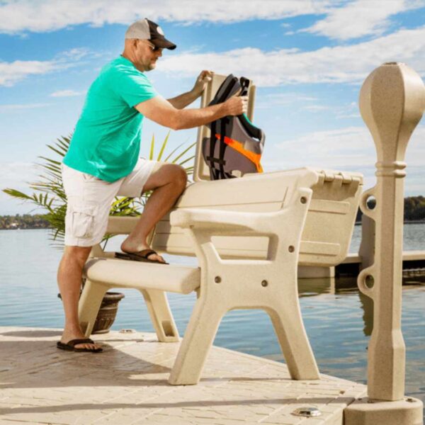 Man placing a life jacket into a Dock Bench Box on a lakeside dock