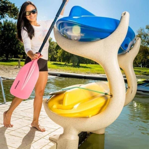 Woman placing a kayak on Wave Dock Kayak/Canoe Rack with two stored kayaks