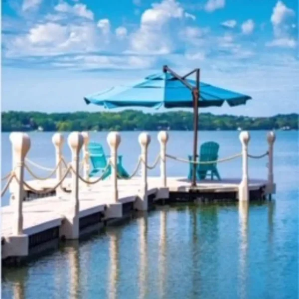 Umbrella mounted on Wave Armor dock with lakefront chairs and rope railing