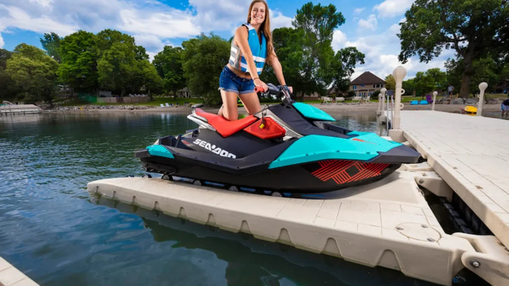 Woman standing on a Sea-Doo jet ski docked on a Wave Armor floating PWC port.