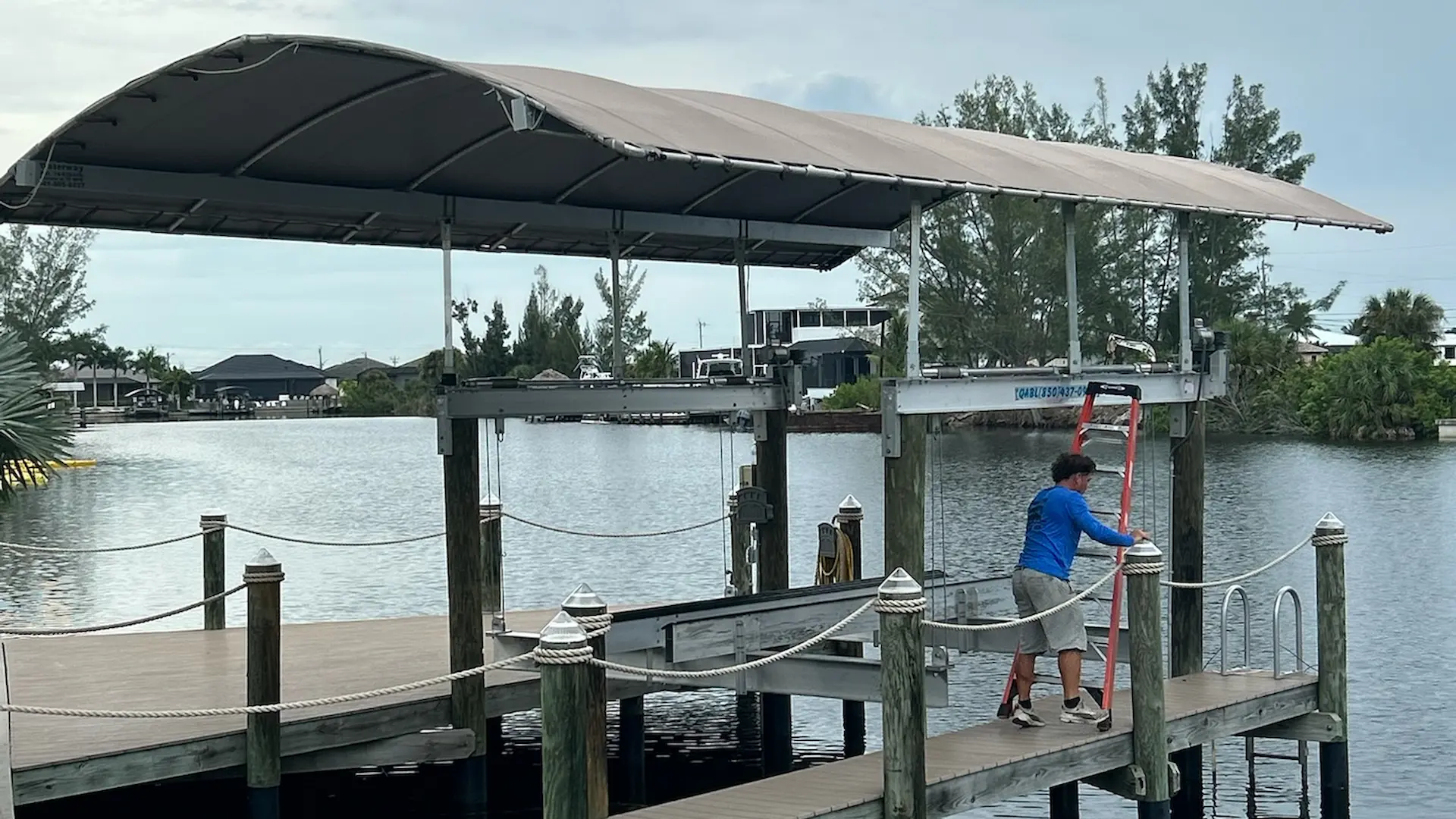 Boat lift installation on a Florida waterfront dock with canopy cover.