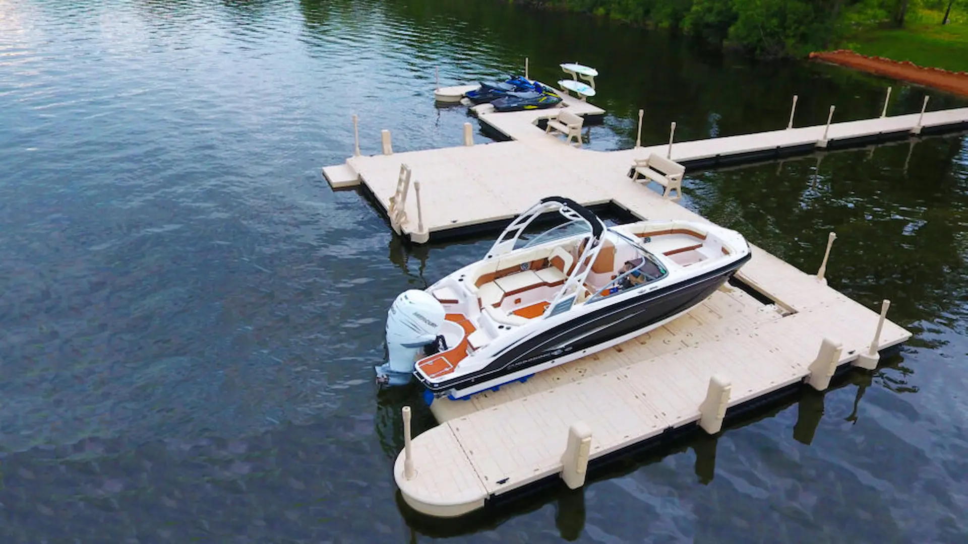 Luxury boat docked on a Wave Armor floating dock system with PWC ports in the background.