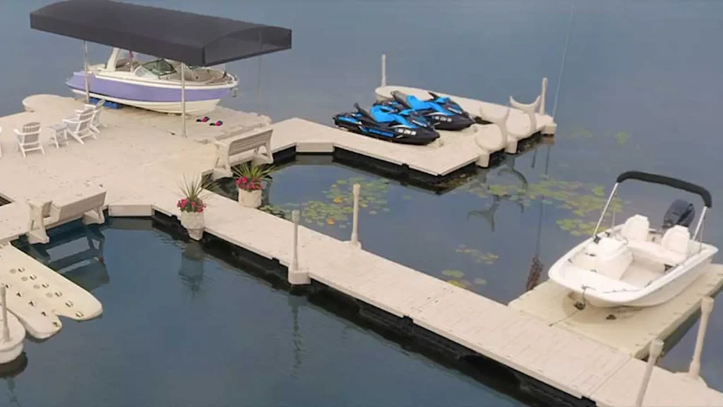 Wave Armor modular dock system with pontoon boat, center console boat, and multiple jet skis on floating PWC ports.