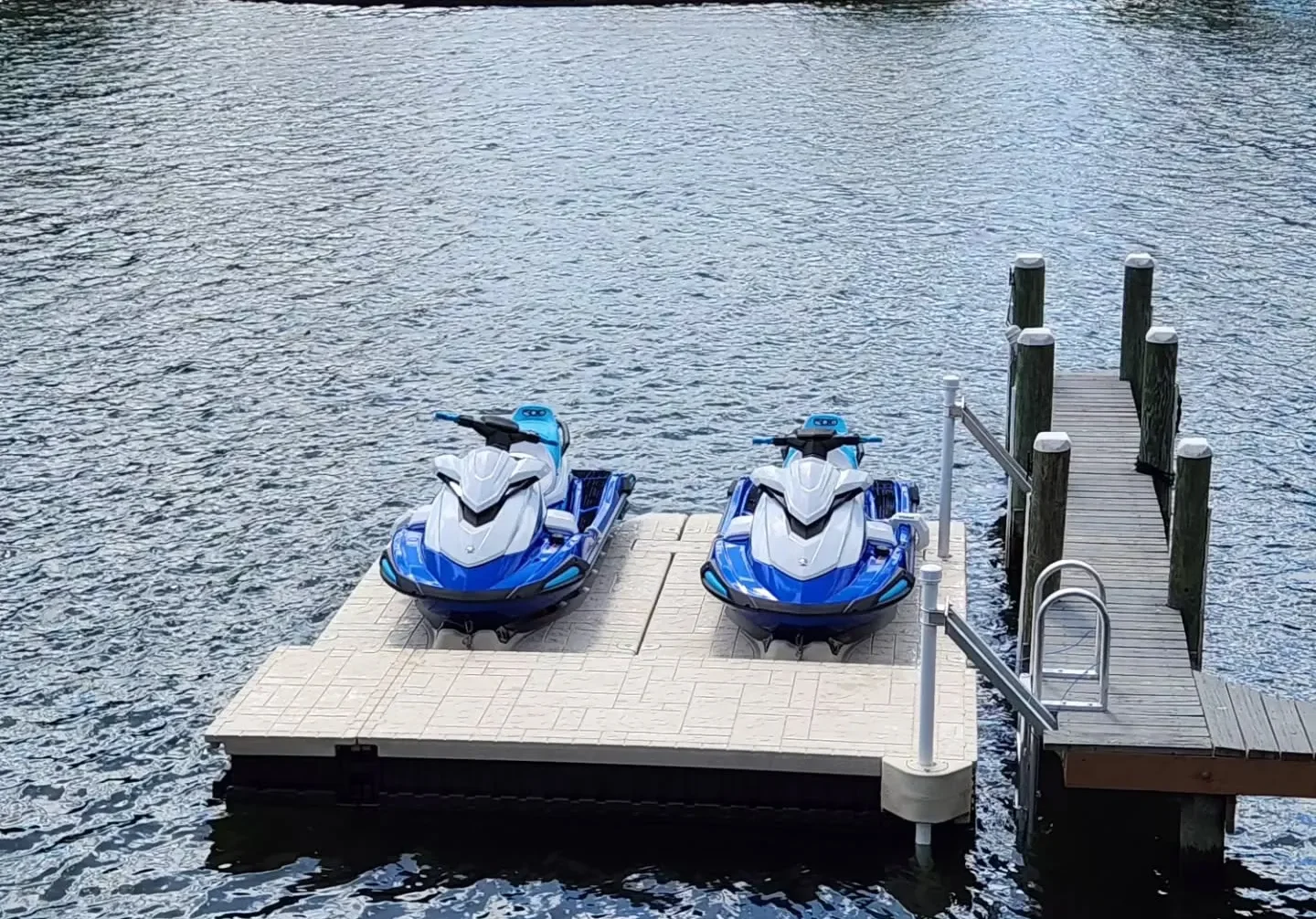 Best Jet Ski Dock: Dual Wave Armor floating PWC ports with two blue and white Yamaha WaveRunners docked next to a wooden pier.