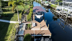 Aerial view of a boat lift with canopy and dock system installed on a Cape Coral waterfront property.