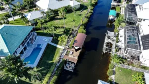 Aerial view of a boat lift with canopy and dock system on a Cape Coral canal waterfront.