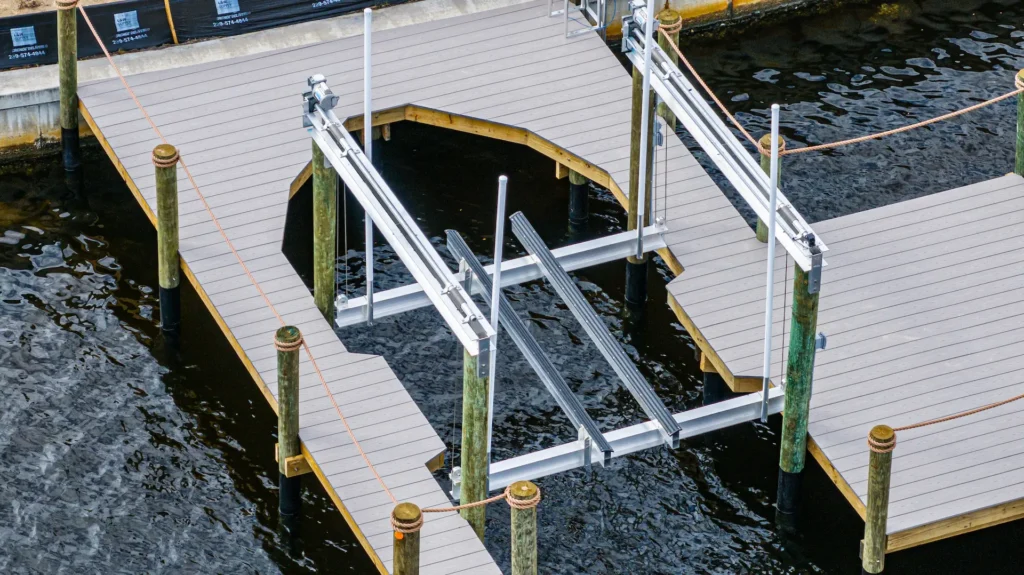 Close angled view of an aluminum boat lift frame integrated into a composite dock on a Florida waterfront.