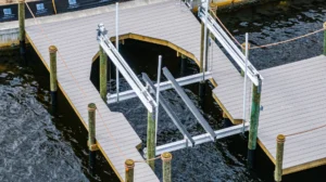 Close angled view of an aluminum boat lift frame integrated into a composite dock on a Florida waterfront.