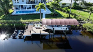 Aerial view of a boat lift with canopy and dock installed on a Florida waterfront property.