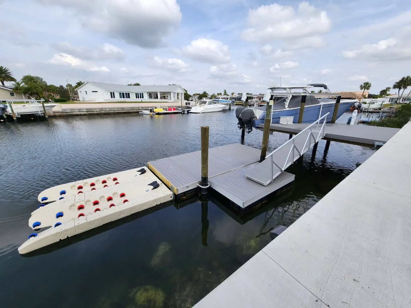 Jet Ski DocksProfessional installation of a Wave Armor jet ski port and floating dock system featuring an aluminum ramp for easy access in a residential waterfront setting.