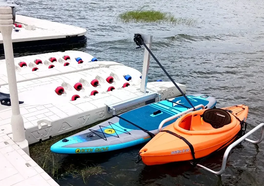 Jet Ski Dock Performance: A white and blue Hurricane Coastal Edition deck boat secured to a tan floating drive-on boat lift in a shallow waterway.