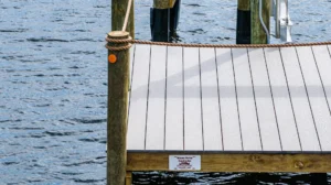 Close-up view of a MacDuff Marine dock installation with composite decking and rope-wrapped piling on a Florida waterfront.