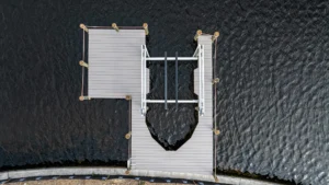Top-down aerial view of an aluminum boat lift and dock installation along a Florida canal seawall.