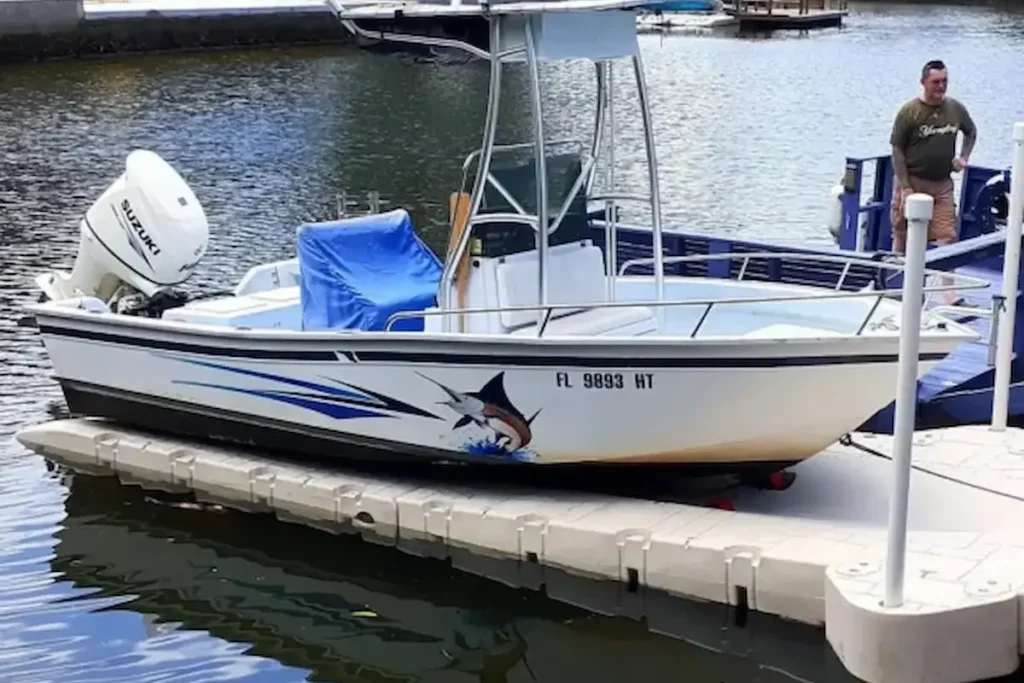Fishing boat secured at a floating boat dock in a marina with water and dock walkway visible in the background.