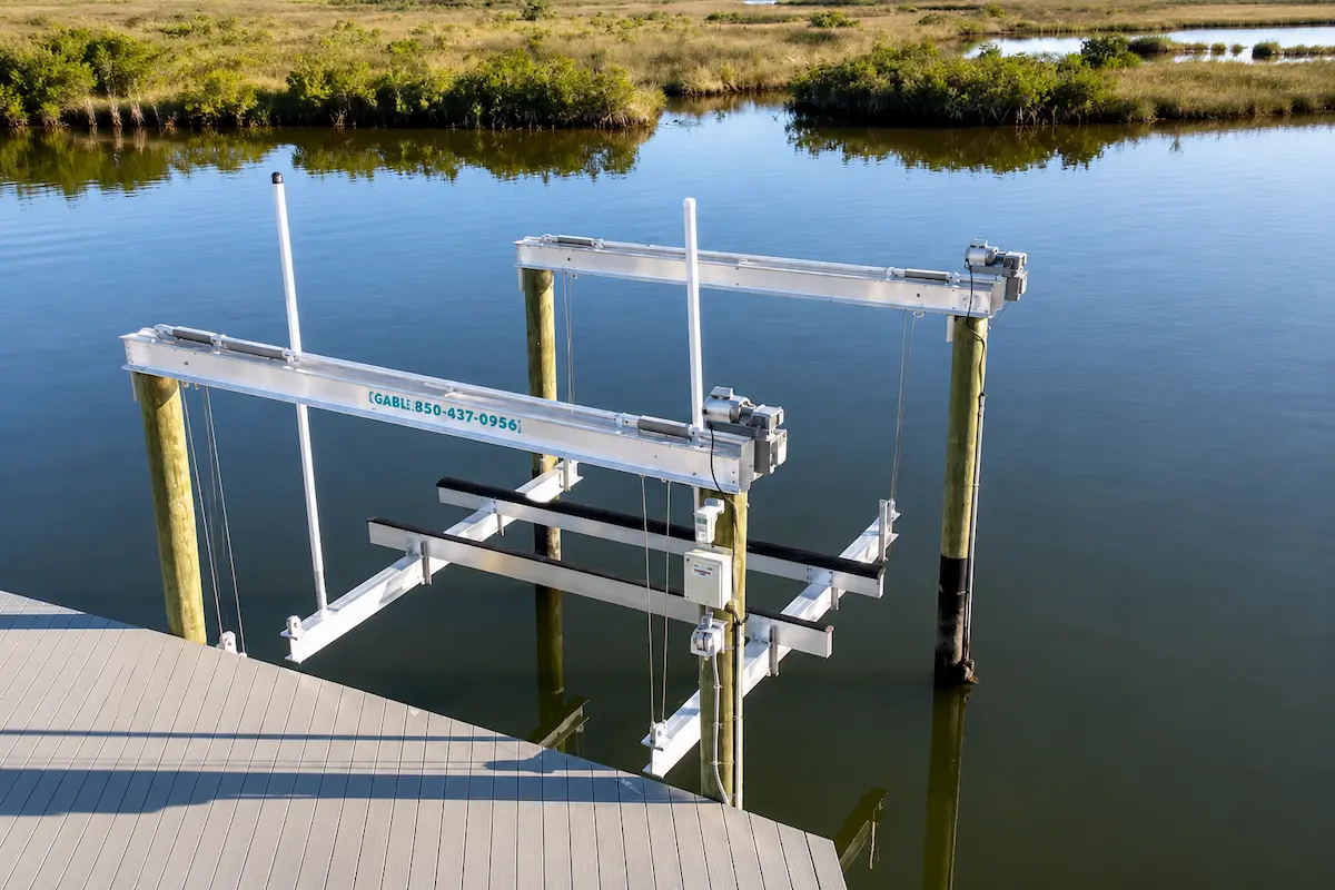 Professional aluminum boat lift installation beside a waterfront dock