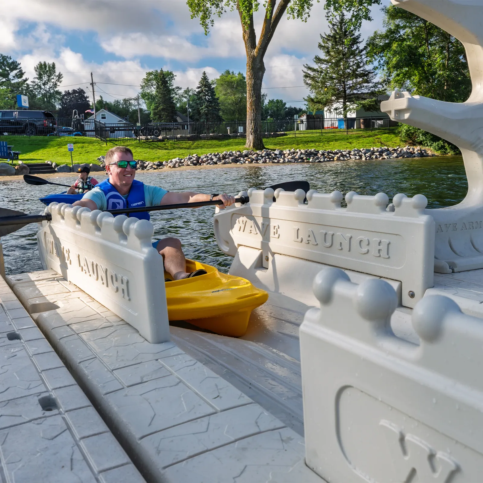 Paddler seated in a kayak on a Wave Armor Kayak Launch with 2 Rails at a dock