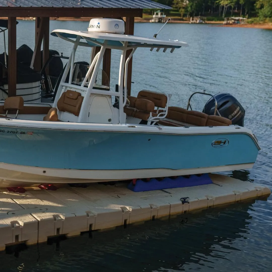 Center console boat resting under a canopy on a Wave Armor floating port